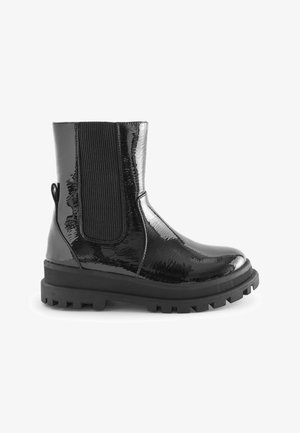 Crne gležnjače od lakirane kože s elastičnim bočnim panelima, čvrstim gumenim potplatom i pričvršćenom trakicom na leđima za lakše obuvanje.