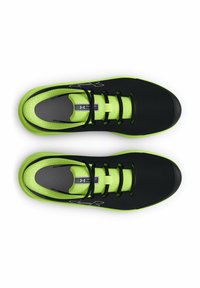 Baskets de sport noires avec des accents verts, tige en mesh, fermeture à lacets et finition texturée. Présente un logo sur le côté et un intérieur rembourré.
