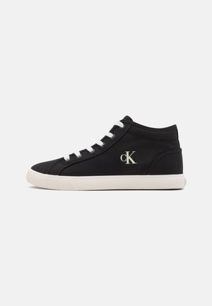 Melnas augstās kedas, izgatavotas no kanvas, ar baltām šņorēm un gumijas zoli. Sānos ir neliels zelta "ck" logotips.