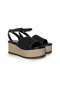 Sandalias de plataforma negras con amplia punta descubierta, correa en el tobillo y base tejida beige. Parte superior sintética suave con un detalle de costura blanca en contraste.
