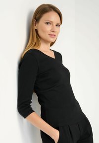 Czarny długi rękaw bluzka z dekoltem w kształcie litery V i dopasowanym krojem, wykonana z prążkowanej tkaniny, z subtelnymi detalami przeszycia wzdłuż szwów.