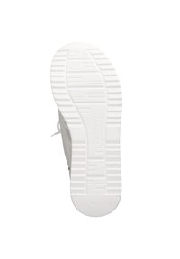 White sneaker sole with a textured grip pattern. The material appears rubberized, featuring a subtle logo and functional lacing on the side.