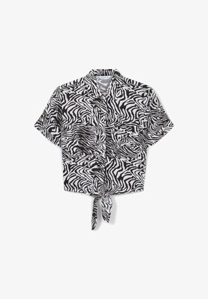 Camicetta corta a maniche corte in stampa zebra bianca e nera, con un dettaglio di legatura frontale e due tasche sul petto. Tessuto leggero.