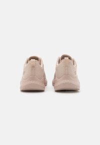 Light pink athletic shoes with a textured mesh upper, cushioned soles, and pull tabs at the rear. Rounded shape and flexible design.