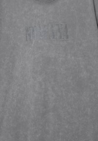 Grå crewneck sweatshirt med et falmet sort grafisk design, der står "NIRVANA" trykt på fronten, lavet af et blødt, tekstureret stof.