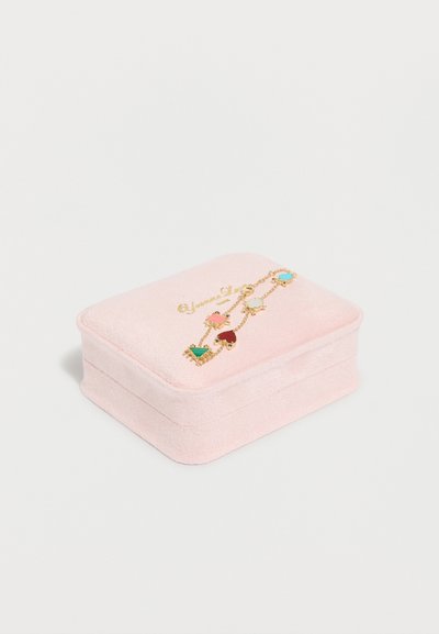 Μαλακό ροζ βελούδινο κουτί κοσμημάτων με ένα βραχιόλι αλυσίδας από χρυσό, που παρουσιάζει πολύχρωμα γεωμετρικά και καρδιάς σχήματος γούρια στην κορυφή.