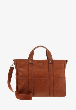 Sac fourre-tout en cuir synthétique marron avec deux poignées supérieures et une bandoulière amovible, présentant une surface texturée et un patch étiqueté sur le devant.