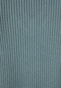 Teksturowana, jasnoniebieska tkanina z pionowym wzorem prążkowanym, wykonana z gęstych, miękkich włókien. Równomierne rozłożenie koloru na całej powierzchni.