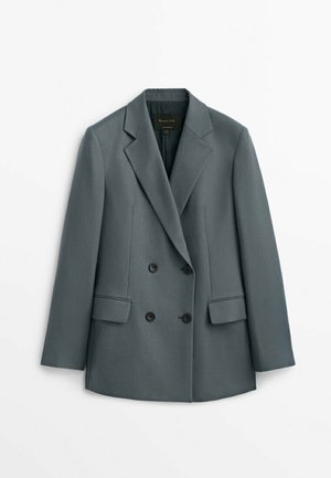 Blazer gris foncé à double boutonnage avec revers crantés et deux poches avant à rabat, présenté à plat sur fond blanc.