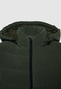 Giacca imbottita verde con cappuccio, dotata di una zip frontale e coulisse regolabili. Il tessuto ha una texture liscia e trapuntata.