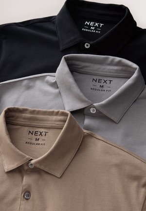 Trīs polo krekli ar apkakli melnā, pelēkā un bēšā krāsā. Katrs ir regulāras piegriezuma, ar uzrakstu uz etiķetes "NEXT M" un pogu detaļām apkaklē.