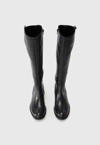 Sorte skinnknee-high støvler med glatt tekstur, rund tå og glidelås på siden. Har en flat såle og minimal sømdetalj.