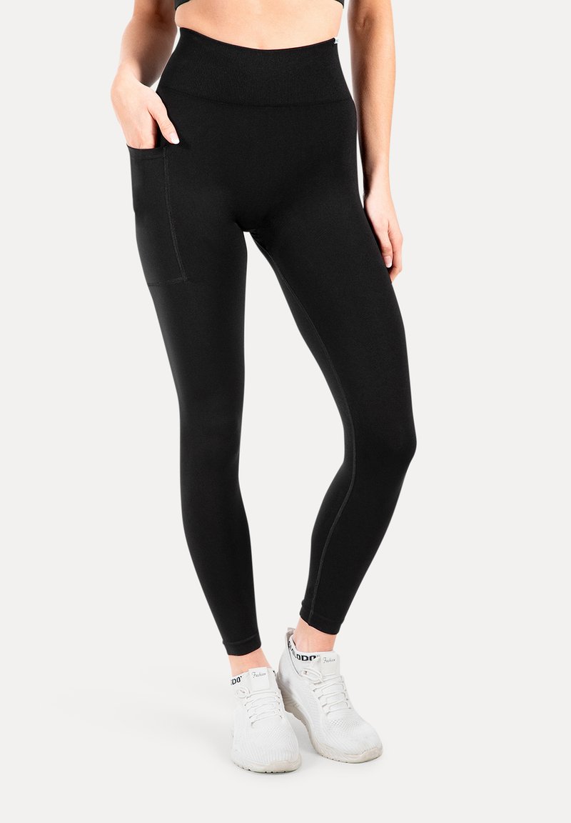 Leggings negros con cintura alta, que cuentan con un bolsillo lateral, fabricados con un tejido elástico, de textura suave y diseño ajustado.