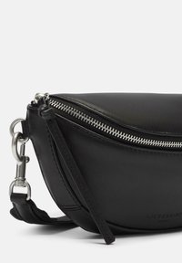 Borsa a tracolla nera in pelle, forma curvata, dettagli in metallo argentato, cinturino staccabile, texture liscia, logo impresso in modo sottile sul lato.