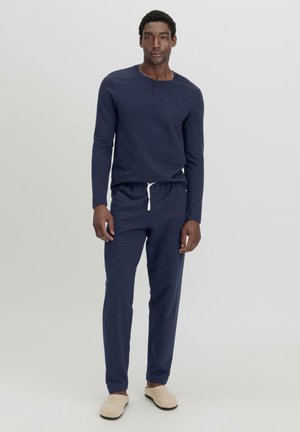 Marinefarbener Langarm-Henley-Shirt mit drei Knöpfen, kombiniert mit passenden Jogginghosen mit Kordelzug. Weicher Stoff, entspannte Passform und lässiger Stil.