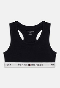Soutien-gorge de sport en coton noir avec un design dos nageur et une bande blanche arborant le logo "TOMMY HILFIGER" en rouge et bleu. Pour les tailles 8-10 ans.