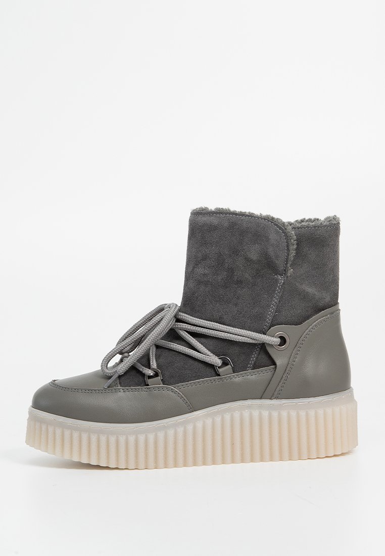 Szare botki za kostkę wykonane z zamszu i skóry, z miękkim wnętrzem, płaską gumową podeszwą oraz wyraźnym sznurowaniem z szarymi sznurówkami.