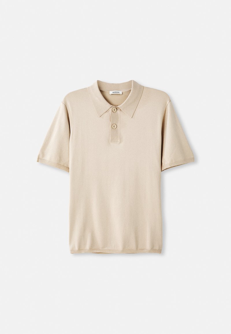 Beige pikétröja med krage och treknäppning. Korta ärmar, mjuk textur och rak nederkant. Minimalistisk design.