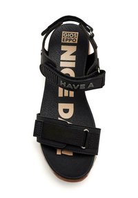 Sandalia negra con suela de goma, con correas de tela ajustables. La plantilla tiene impreso "HAVE A NICE DAY" en colores contrastantes.