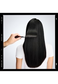 Czarne włosy czesane grzebieniem o drobnych zębach, pokazujące gładką teksturę i prosty styl, na neutralnym tle.