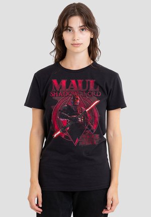 Junge Frau trägt schwarzes T-Shirt mit roter Grafik von Darth Maul mit doppelklingigem Lichtschwert und dem Text „Maul Shadow Lord.“