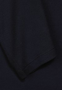 Marinblå stickad tyg med en ribbad struktur. Har en ren mudd och släta sömmar längs kanterna.