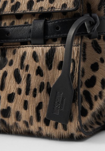 Geantă de mână cu imprimeu leopard, cu o textură pufoasă, accente din piele neagră și un etichetă cu branding embossat. Designul include o formă elegantă.