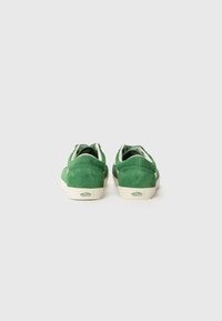 Grønne semskede sneakers med lav profil, off-white såler og en label på hælen. Har et enkelt design med kontrastfargede hvite snørebånd.