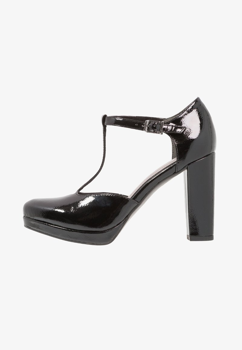 Chaussure à talon haut en cuir verni noir avec design à bride en T, talon épais, bout arrondi et boucle à la cheville pour ajustement. Texture brillante et lisse.
