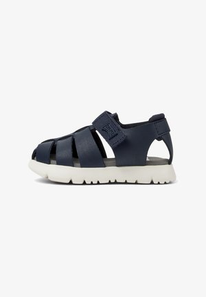 Granatowe sandały wykonane z materiału syntetycznego, z otwartym palcem, wyposażone w rzep oraz białą gumową podeszwę z teksturowanym wzorem.