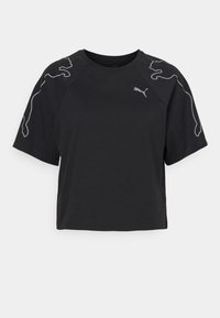 Camiseta negra cortada de algodón, con mangas cortas. Destaca el logo Puma gris y un diseño gráfico en los hombros. Textura suave.