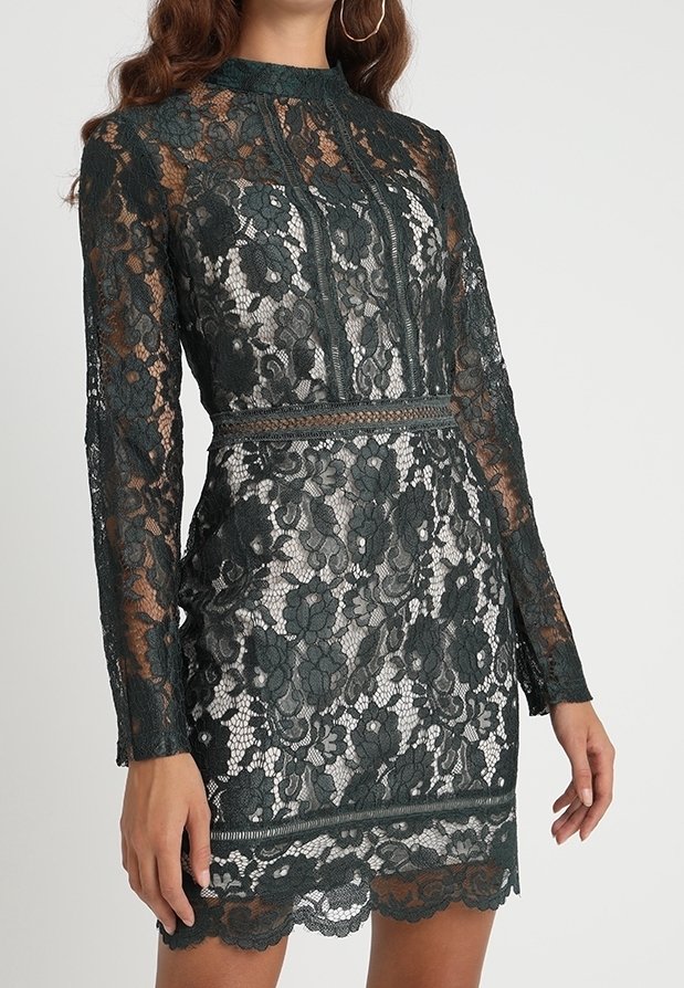 Robe en dentelle vert foncé avec des manches longues, un col montant, un motif floral, une doublure contrastante, une silhouette ajustée et un ourlet festonné.