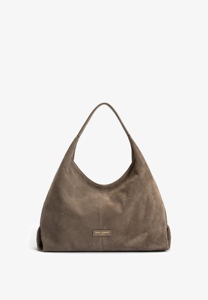 Suede hobo bag in brown, featuring a wide shoulder strap, soft texture, and a rectangular logo patch on the front. Seam detailing visible.
