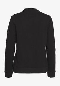 Czarna bluza z mieszanki bawełny, z okrągłym dekoltem, długimi rękawami oraz boczną kieszenią na lewym ramieniu. Prosty, minimalistyczny design.