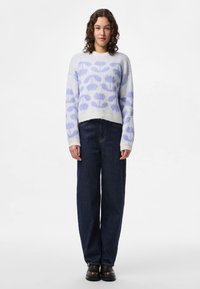 Ljusblå och vit stickad tröja med blommönster, rund halsringning och ribbade ärmslut, kombinerad med marinblå vida jeans och svarta stövlar.