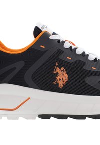 Czarne sneakersy z pomarańczowymi akcentami, teksturowana siateczkowa cholewka, białe sznurówki i biała podeszwa z wyraźnym logo gracza polo.