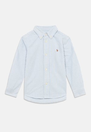 Camisa de manga comprida com botões, em riscas verticais azul claro e branco. Tecido de algodão, gola pontiaguda, logótipo bordado no peito, bainha arredondada.