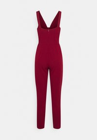 Burgundijas krāsas jumpsuits ar pieguļošu dizainu, V-veida dekoltē, ar rāvējslēdzēju aizmugurē un sašaurinātām kājām, izgatavots no izlīdzinātas, elastīgas auduma.