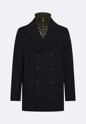 Cappotto navy doppiopetto con ampi revers, tasche frontali e un colletto alto a coste sotto. Tessuto liscio con dettagli di bottoni.