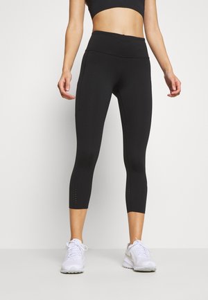 Leggings negros con una cinturilla completa y longitud recortada. Presentan perforaciones transpirables cerca del fondo y una tela suave y elástica.