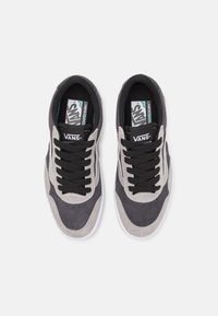 Vans topánky s nízkym dizajnom, šedým a čiernym semišovým materiálom, čiernymi šnúrkami a kontrastnými bielymi podrážkami s polstrovanými stielkami.