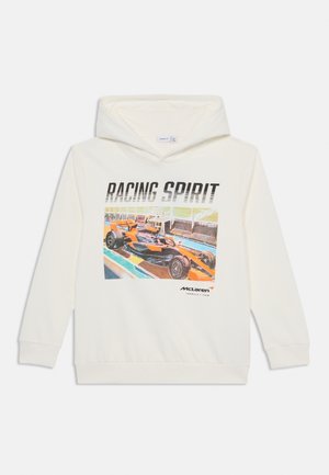 Hvid hættetrøje med en levende orange og sort Formel 1 racerbilsdesign med teksten "RACING SPIRIT" og McLaren-logo foran.