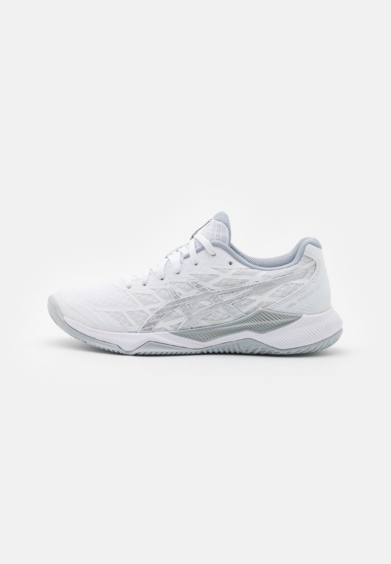 Zapatilla deportiva blanca con parte superior de malla texturizada y detalles en gris. Presenta una suela acolchada y una suela de goma flexible para mayor tracción.