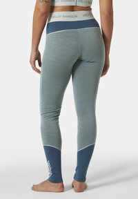 Leggings de color azul claro con una cinturilla azul marino, tejido texturizado y acentos contrastantes azul marino a lo largo de las piernas, con un estampado de logo.