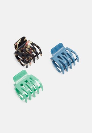 Conjunto de três molas para cabelo: uma preta com padrão de tartaruga, uma azul-clara e uma verde. Todas são feitas de plástico com um acabamento mate.
