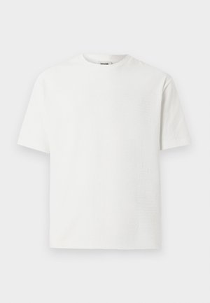 Camiseta blanca de manga corta con un patrón texturizado, cuello redondo y corte relajado. La tela parece ligera y transpirable.