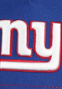 Blue cap featuring raised white and red embroidered text reading "NY." The fabric is textured, with visible stitching details.
