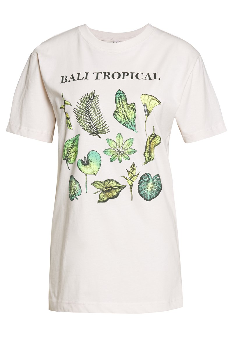 Gaiši bēšs kokvilnas t-krekls ar botānisko apdruku, kas attēlo dažādas zaļas lapas, virs dizaina melnā krāsā ir teksts "BALI TROPICAL".
