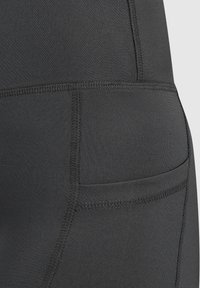 Leggings sportivi neri con una texture liscia, dotati di una tasca laterale e cuciture piatte per comfort e durabilità.