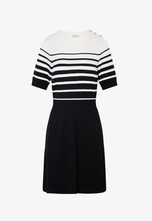 Kortærmet kjole med hvide og sorte vandrette striber på toppen, sort nederdel og tre guldknapper på venstre skulder.